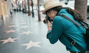 turista fotografando as estrelas na Calçada da Fama em Hollywood durante viagem aos Estados Unidos